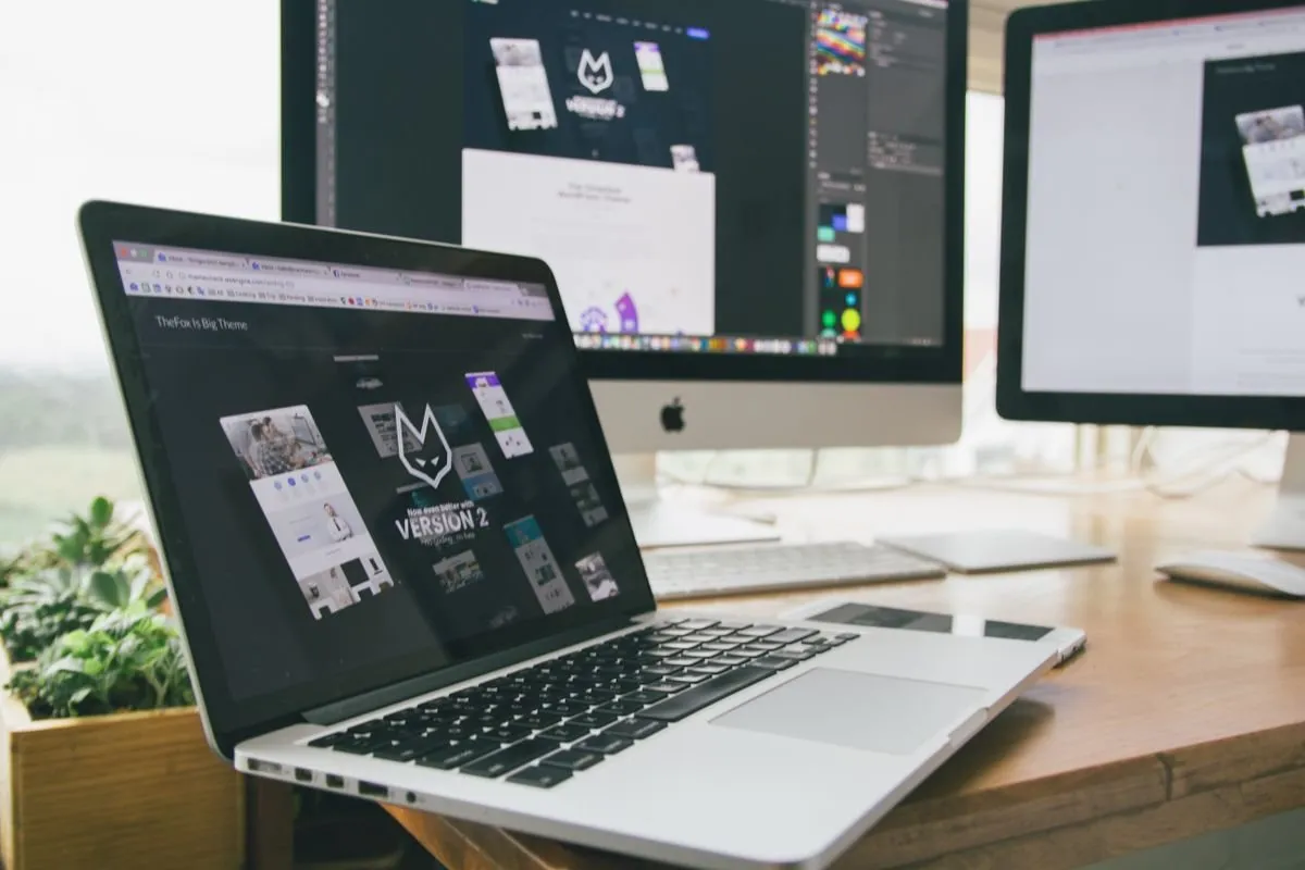 A laptop screen showing a responsive website design on a work desk